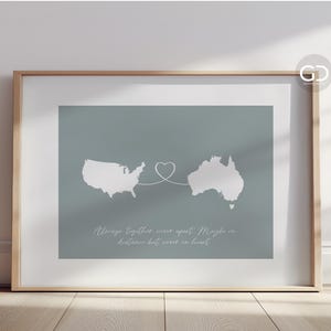 May include: A framed print with a light blue background featuring outlines of the United States and Australia connected by a heart shape. The text reads "Always together even apart. Maybe in distance but always in heart."