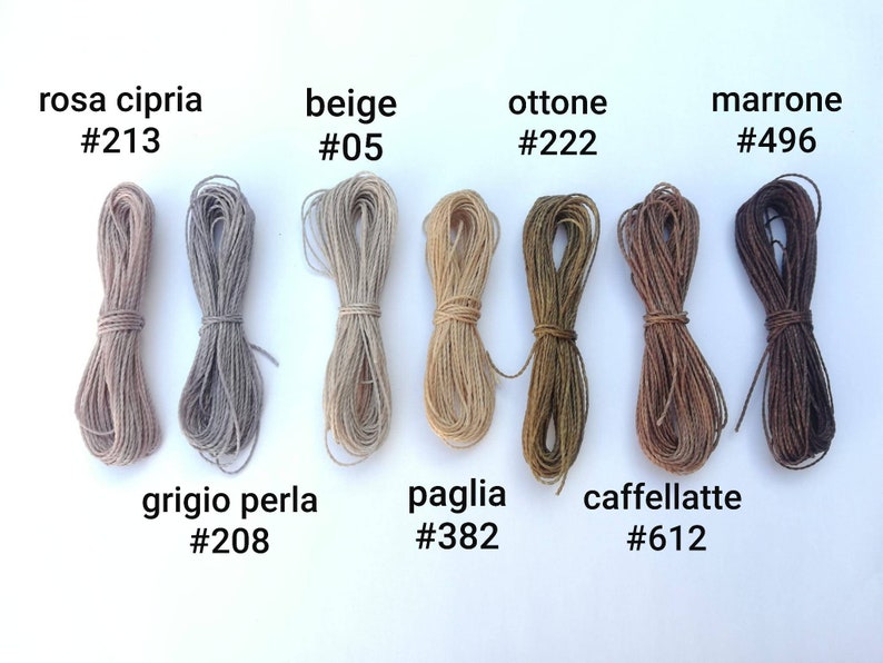 K&ouml;nnte beinhalten: Acht Spulen mit naturfarbenen Garnen, angeordnet in zwei Reihen zu vieren. Die Garnfarben sind: rosa cipria #213, beige #05, ottone #222, marrone #496, grigio perla #208, paglia #382, caffellatte #612.