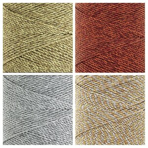 K&ouml;nnte beinhalten: Vier Spulen mit Metallic-Garn. Die Spulen sind in einem Raster angeordnet. Die Garnfarben sind Gold, Rot, Silber und Gold und Silber.