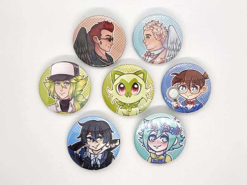 May include: Set of 7 round button pins featuring various cartoon characters. The characters include a green cat, a person with green hair wearing a white hat, a person with brown hair wearing a blue suit, a person with black hair wearing a black suit, a person with blonde hair wearing a white shirt, and a person with brown hair wearing a white shirt.