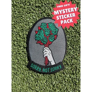 May include: A gray embroidered patch with a hand holding a bouquet of green roses. The text "Sorry, Not Sorry" is embroidered in black around the bottom of the patch.