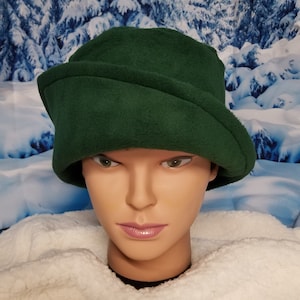 May include: A dark green fleece hat with a folded brim. The hat is made of soft, warm fleece and is perfect for cold weather.