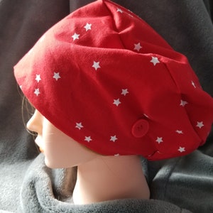 May include: Red fabric scrub hat with white stars and a single button on the side.