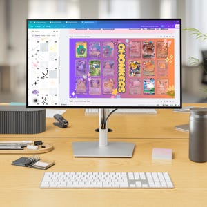 May include: A computer screen displaying a digital design of a card binder with a purple background and a yellow banner that says "CHONKERS". The design features a grid of 20 colorful cartoon images of various creatures. The screen is on a desk with a keyboard and other office supplies.