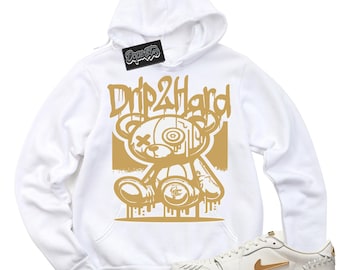 May include: White hoodie with a gold graphic of a teddy bear with the text "Drip2Hard". A pair of white sneakers with gold accents are also pictured.