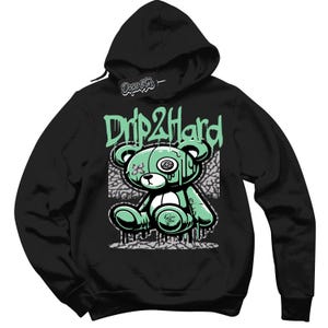 Könnte beinhalten: Schwarzer Kapuzenpullover mit einem grünen, tropfenden Bären-Motiv und dem Text "Drip2Hard" auf der Vorderseite.