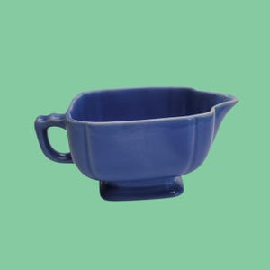 May include: A white ceramic mug with a black handle and the text "But First, Coffee" in a handwritten style. The mug is on a white surface. The mug is 4 inches tall.