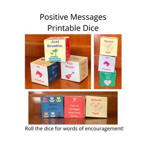 May include: A set of six colorful dice with positive messages printed on each side. The dice are made of cardboard and have a variety of designs, including a flamingo, a guitar, and a flower. The dice are stacked on top of each other and are arranged in a pyramid shape. The dice are a fun and encouraging way to add a little positivity to your day.