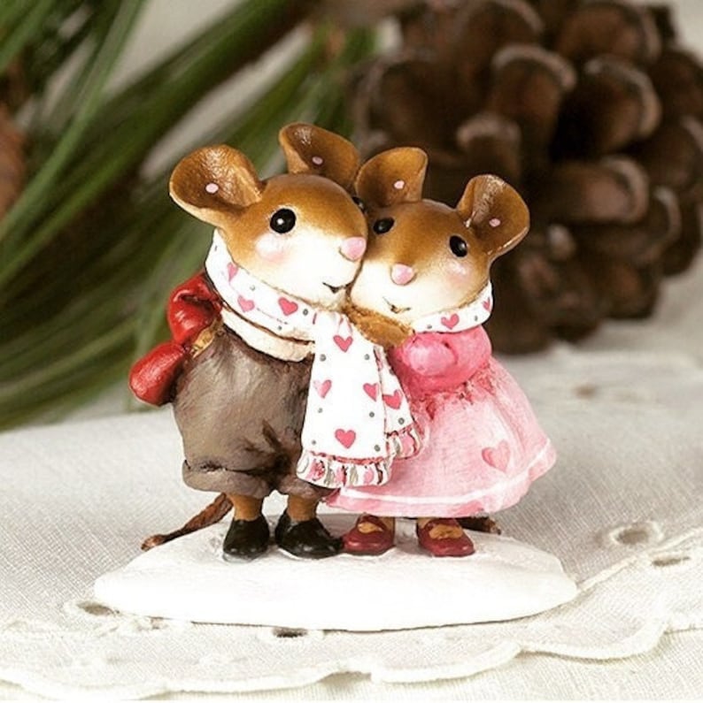 A Wee Forest Folk miniature figurine of two adorable mice in love, standing cheek-to-cheek, wearing a scarf with heart motifs holding them close together.