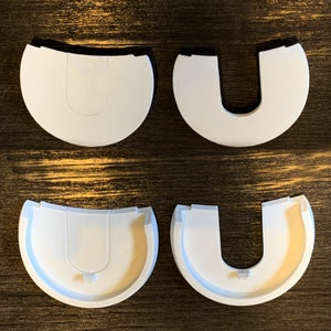 May include: Four white plastic U-shaped pieces. The pieces are designed to be used as a replacement part for a product.