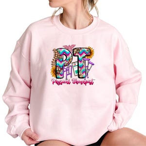 a woman wearing a pink sweatshirt with the word phi on it
