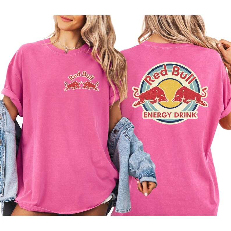 A woman wearing a pink t-shirt with the Red Bull logo and the text "Red Bull ENERGY DRINK" printed on it.