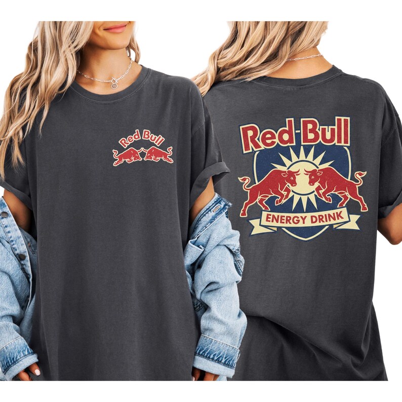 a woman wearing a grey t-shirt with the Red Bull logo and a graphic of two bulls.