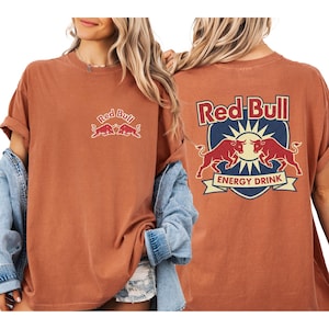 A woman wearing a red bull t-shirt with the Red Bull logo and the text "Red Bull ENERGY DRINK" on the back.