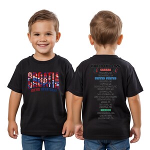 A young boy wearing a black t-shirt with text and graphics printed on it.