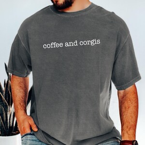 a man wearing a coffee and corgis t - shirt