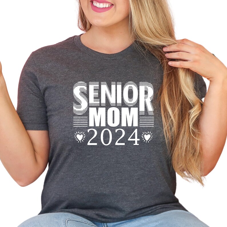 May include: A dark gray t-shirt with the text "Senior Mom 2024" in white with two small white hearts on either side of the year.
