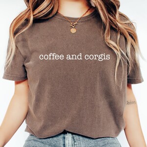 a woman wearing a coffee and corgis t - shirt
