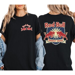 A woman wearing a black t-shirt with the Red Bull logo and a graphic of two bulls.