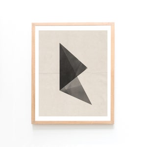 Puede incluir: Una impresión enmarcada con un diseño geométrico negro y gris sobre un fondo beige.