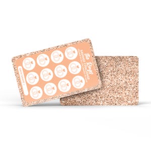 May include: A peach-coloured savings challenge card with a glittery border and the text "The Rings Savings Challenge". The card features white circles with wedding ring graphics. A second, similar card is behind it.