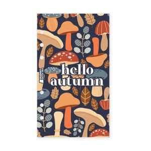 May include: A rectangular design with a dark blue background, patterned with orange, beige, and red mushrooms, brown leaves, and green sprigs. The words "hello autumn" are in white.