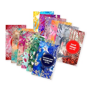 May include: A set of 10 colourful cards with glitter and abstract designs. The cards feature different inspirational quotes, including "Good Things Take Time" and "Budgeted Looks Gorgeous On You".