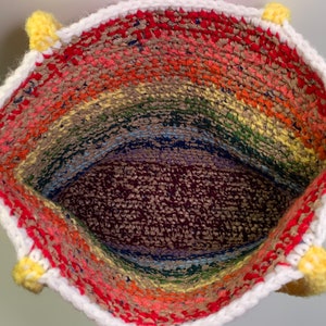 The inside of a crochet bag made with yarn and plastic yarn made from grocery bags.