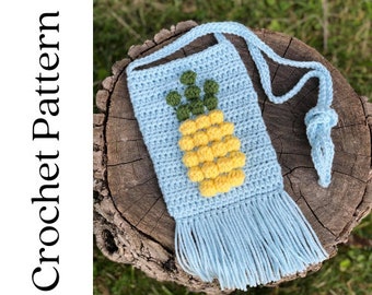 May include: A light blue crocheted pineapple-shaped bag with a long strap and a fringe. The bag is made with yellow, green, and light blue yarn.