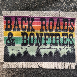 Może przedstawiać: Biała łatka z tkaniny z kolorowym wzorem w paski tęczy i tekstem "Back Roads & Bonfires kinda girl".