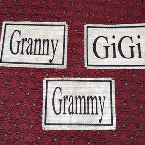 May include: Three white fabric labels with black text. The labels read "Granny", "Gigi", and "Grammy".