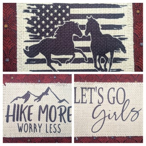 May include: Three burlap patches with black text and images. The first patch features a silhouette of two horses running in front of an American flag. The second patch features a mountain range with the text "Hike More Worry Less". The third patch features the text "Let's Go Girls".