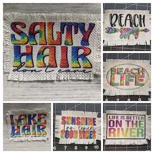 May include: Six colorful fabric patches with various summer-themed phrases. The patches are rectangular and have a frayed edge. The phrases include "Salty Hair Don't Care", "Beach Gypsy", "Beach Life", "Lake Hair Don't Care", "Sunshine Tan Lines Good Vibes", and "Life is Better on the River".