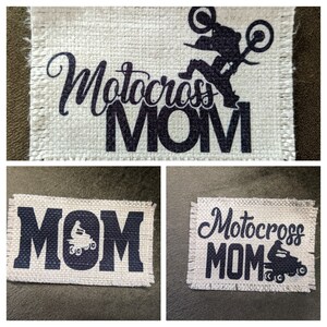 May include: Three burlap patches with the text "Motocross MOM" in black lettering. One patch features a silhouette of a motocross rider. Another patch features a silhouette of a motocross rider with the text "MOM" in large black letters. The third patch features the text "Motocross MOM" in black lettering with a silhouette of a motocross rider.