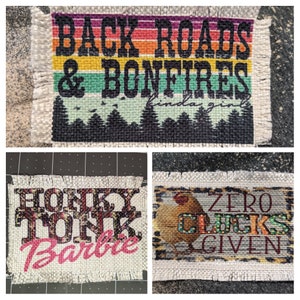 May include: Three burlap patches with colorful text and images. The first patch has a rainbow background with the text "Back Roads & Bonfires kinda girl". The second patch has a pink and black floral design with the text "Honky Tonk Barbie". The third patch has a brown and white animal print background with the text "Zero Clucks Given".