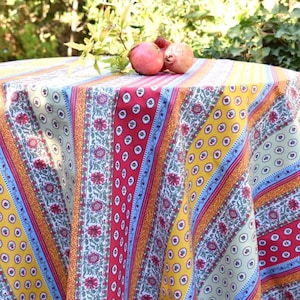 Peut inclure: Une nappe ronde avec un motif rayé coloré en rouge, jaune, bleu et vert. La nappe a un motif floral et est parfaite pour un pique-nique ou un repas en plein air.