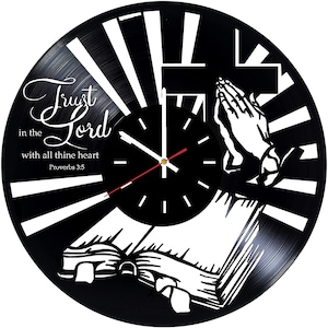 May include: Black vinyl record clock with a white design of a cross, praying hands, and an open book. The clock face is black with white hands and numbers. The text "Trust in the Lord with all thine heart Proverbs 3:5" is printed on the clock.