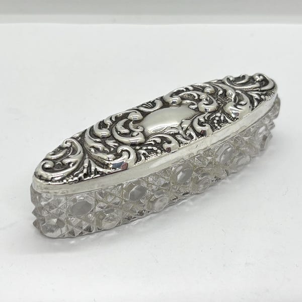 Caja/recipiente de tocador antiguo de cristal tallado con tapa de plata maciza y diseño repujado estilo art nouveau.