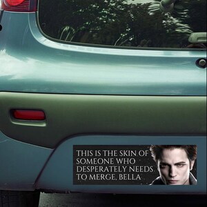 May include: A black and white bumper sticker with a quote from the Twilight movie series. The quote reads "This is the skin of someone who desperately needs to merge, Bella." The sticker features a photo of Edward Cullen, a vampire character from the Twilight series.
