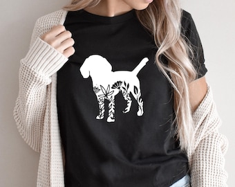 May include: A black t-shirt with a white floral design of a dog silhouette.