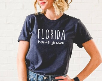 May include: A dark blue t-shirt with white text that reads "FLORIDA home grown".