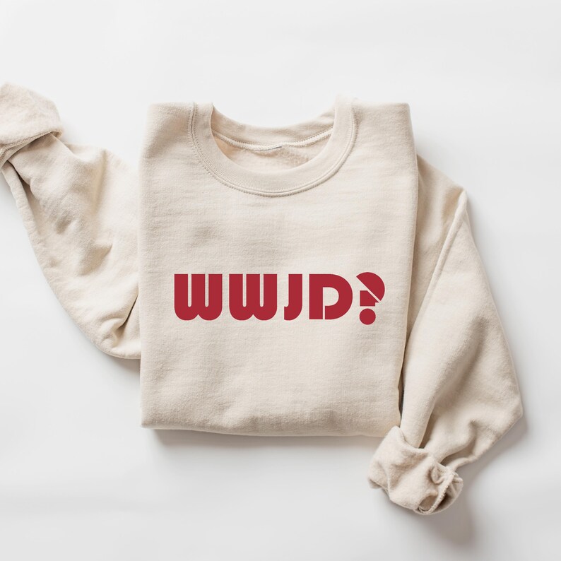 May include: A beige sweatshirt with the text "WWJD?" printed in red on the front.