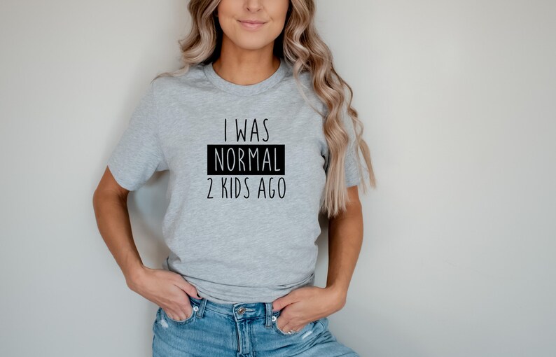 May include: A gray t-shirt with the text "I was normal 2 kids ago" printed in black.