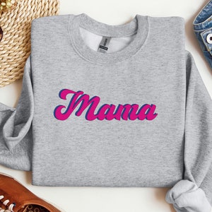 May include: Gray sweatshirt with the word "Mama" in pink and blue lettering.