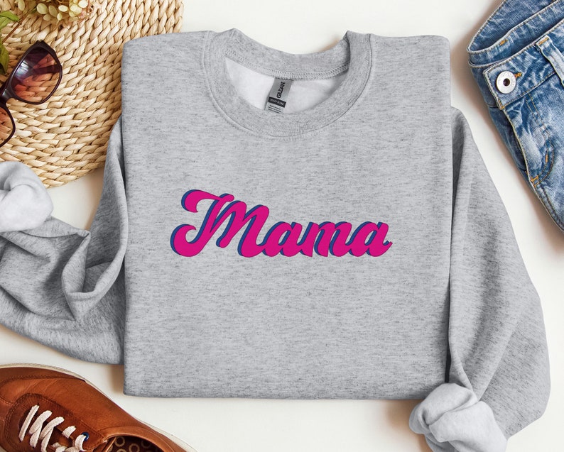 May include: Gray sweatshirt with the word "Mama" in pink and blue lettering.