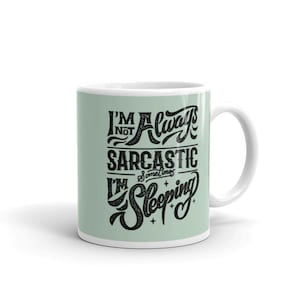 Puede incluir: Taza de cerámica blanca con fondo verde claro y texto negro que dice "No siempre soy sarcástico, a veces estoy durmiendo."