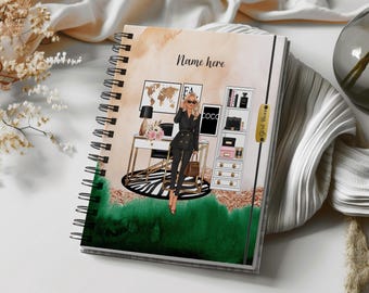 May include: A spiral-bound notebook featuring a graphic illustration of a person in a black suit standing in an office with a desk, a world map, and a shelving unit. The cover includes the text Name here and Girl Boss with a watercolor background.