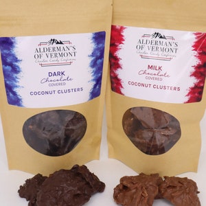 May include: Two brown paper bags with labels for Alderman's of Vermont chocolate candy confections. The bags contain dark chocolate and milk chocolate coconut clusters.