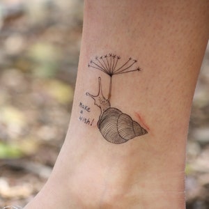 Surrealist snail skull tattoo