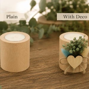Pu&ograve; includere: Due portacandele cilindrici in legno, uno semplice e uno decorato con un piccolo cuore di legno, spago e fiori secchi. Il supporto semplice &egrave; etichettato "Plain" e quello decorato "With Deco" sopra di essi.